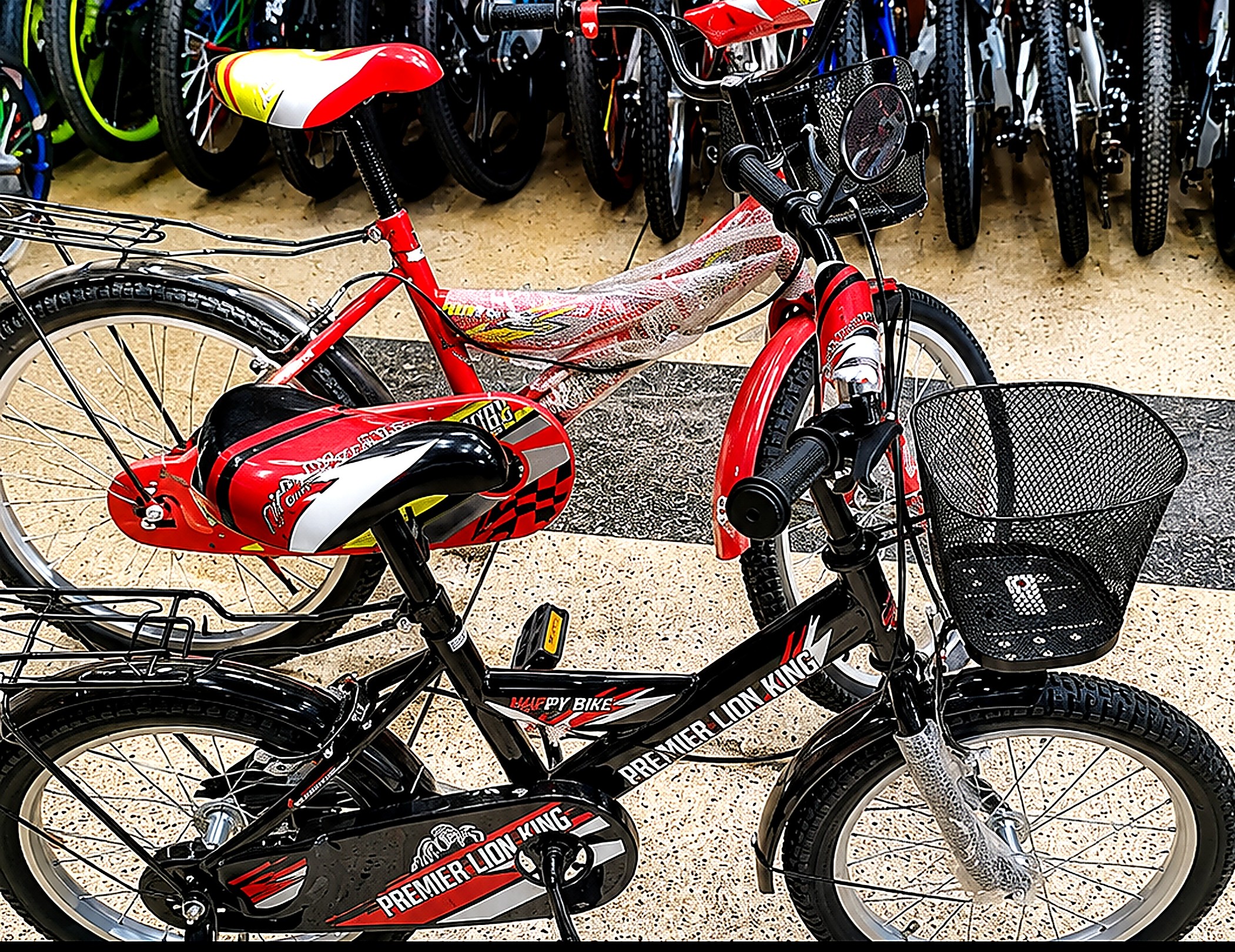 Premier Lion King 16-inch kids bicycle in black with training wheels, front basket, rear carrier, chain guard, mudguards, and comfortable padded saddle.