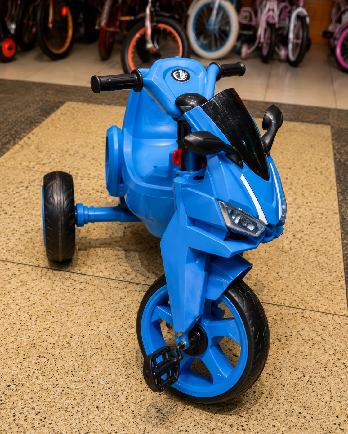 Blue Thunder kids tricycle with sporty motorcycle-style body, three wheels, pedals and black windshield