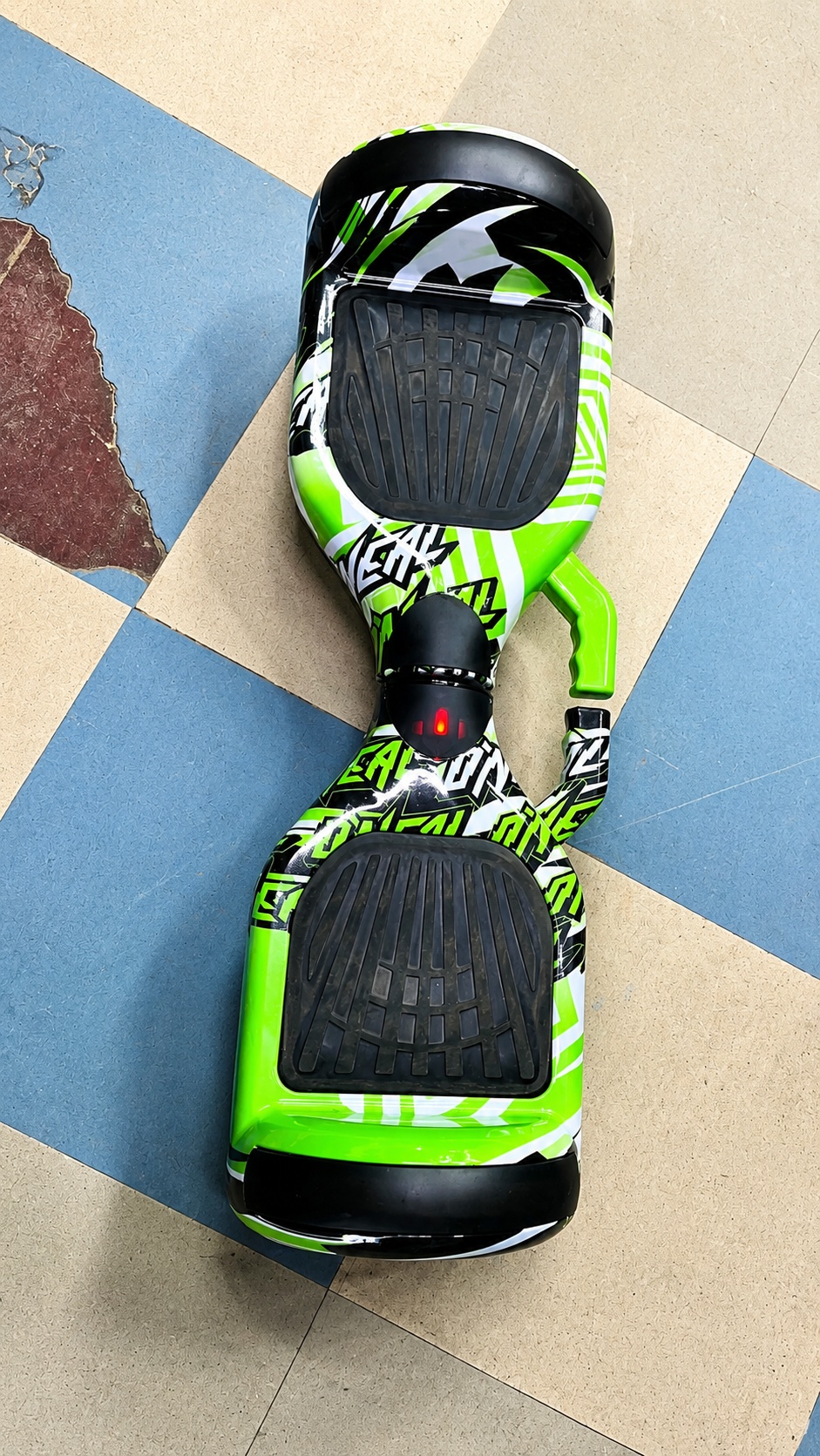 Green self-balancing electric hoverboard with detachable steering handle and anti-slip footpads.