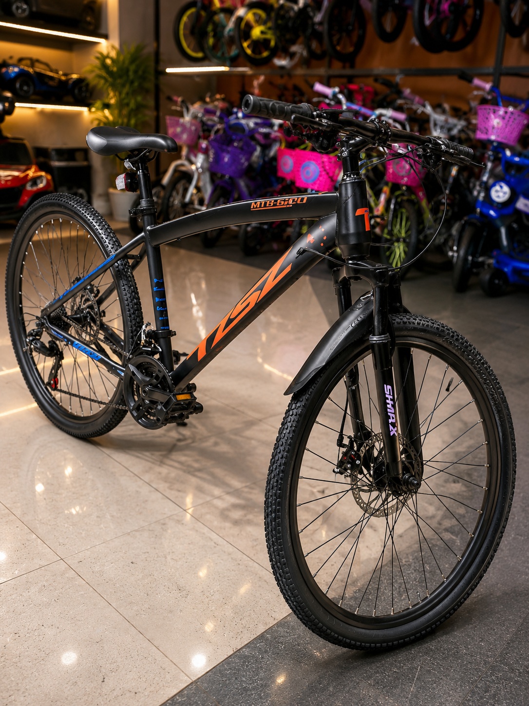 KSZ 26-inch black and orange mountain bike with front suspension and front and rear mechanical disc brakes.