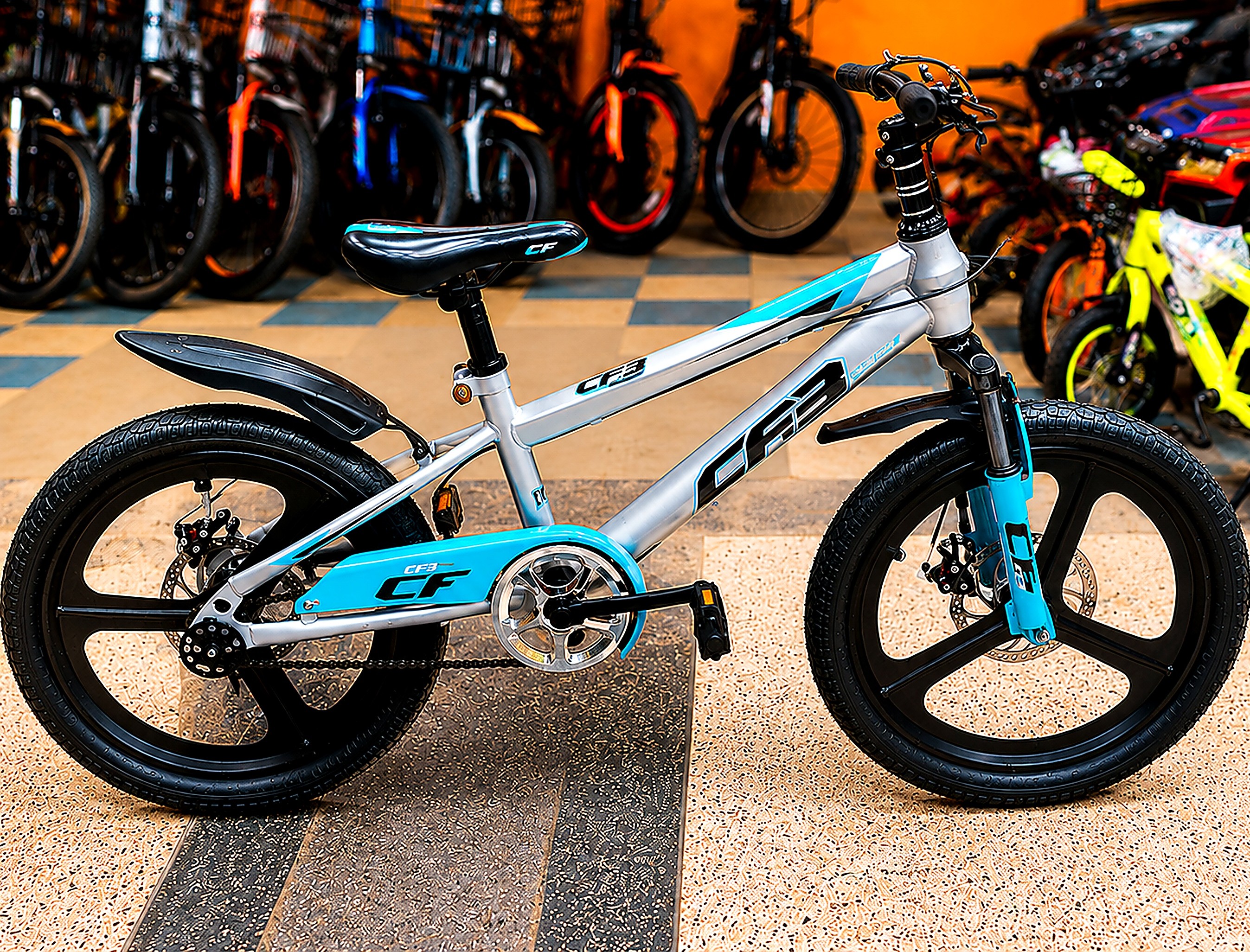 CF3 20-inch kids bicycle in silver and blue with dual disc brakes, alloy mag wheels, front suspension, mudguards, and chain guard.