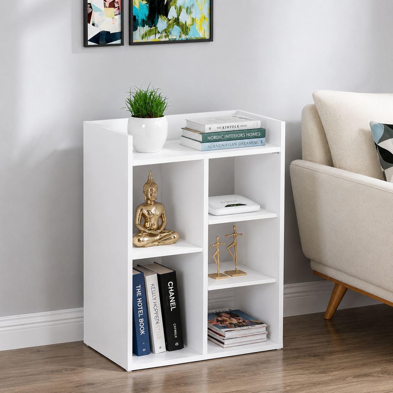 Modern white bookshelf storage unit with open shelves for books, décor, plants, and home accessories in a contemporary living room.