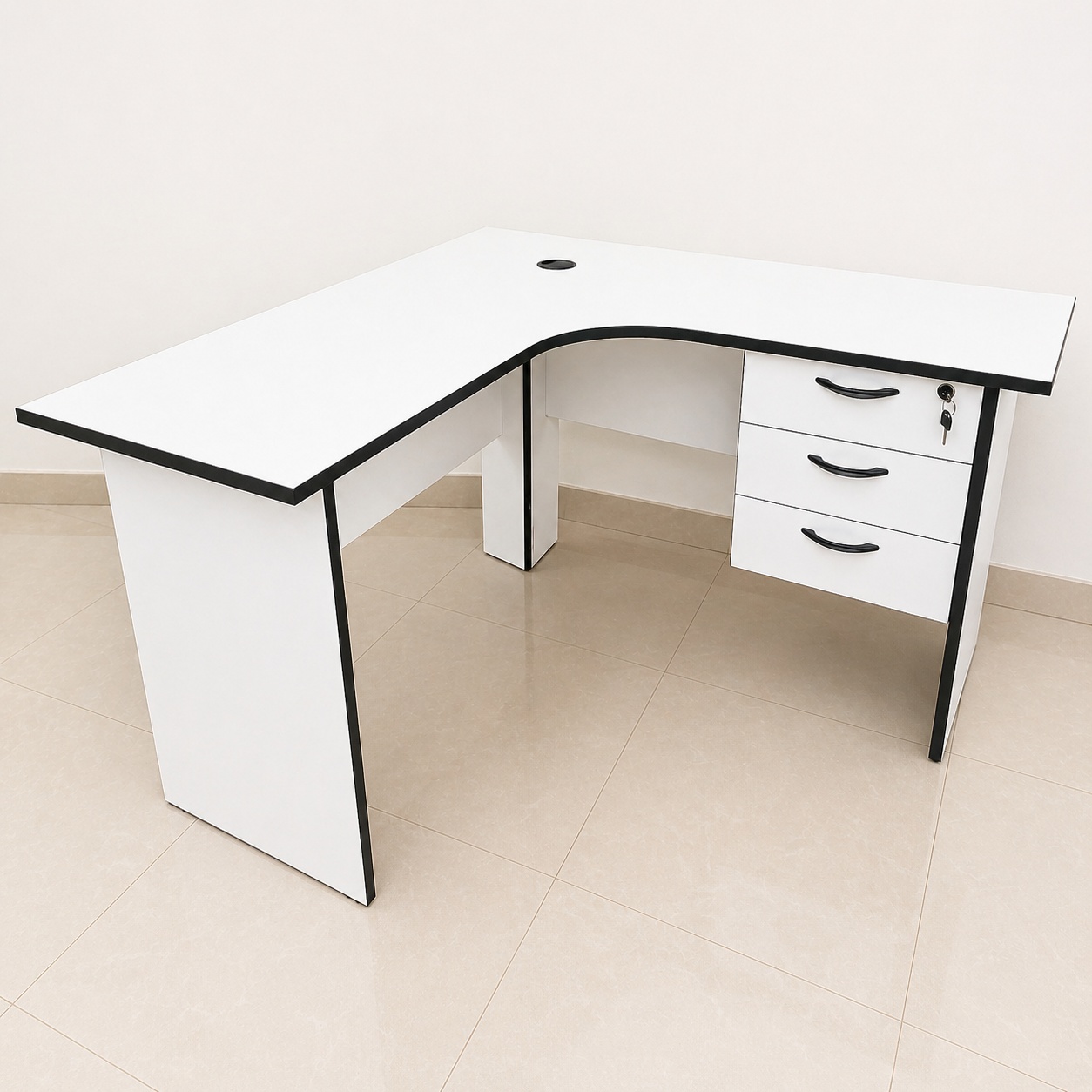 White L-shaped executive office workstation desk with three lockable drawers, cable management port, and black edge trim.